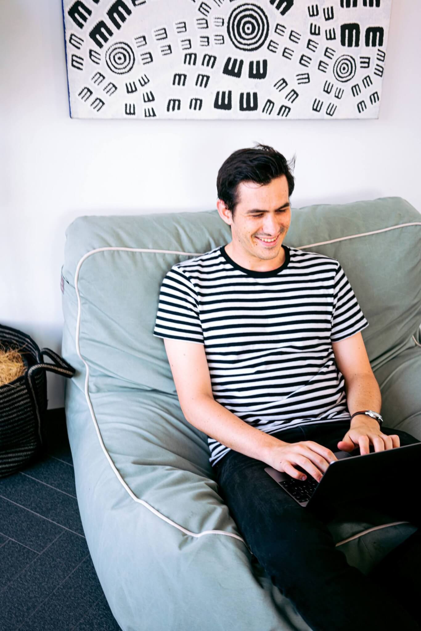 Man in a black and white striped T-shirt working from home